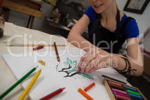 Attentive woman sketching in drawing book