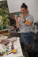 Attentive man painting bowl