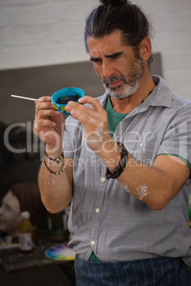 Attentive man painting bowl