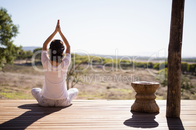 Woman practicing yoga on wooden plank