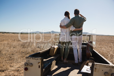 Rear view full length of couple on off road vehicle at landscape