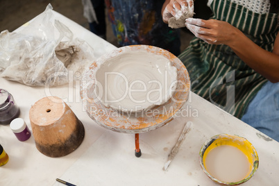 Mid section of woman learning pottery
