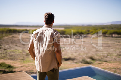 Rear view of man standing near poolside