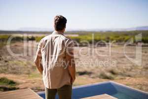 Rear view of man standing near poolside