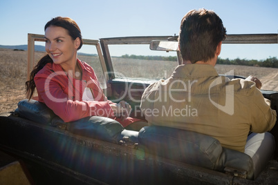 Woman with man looking away in off road vehicle