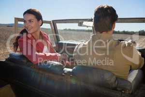 Woman with man looking away in off road vehicle