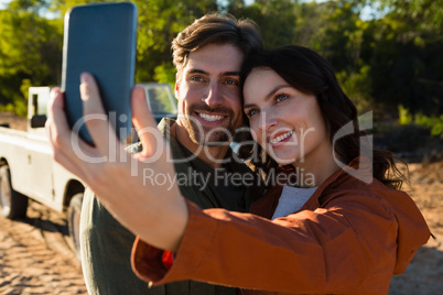 Woman with man taking selfie on field