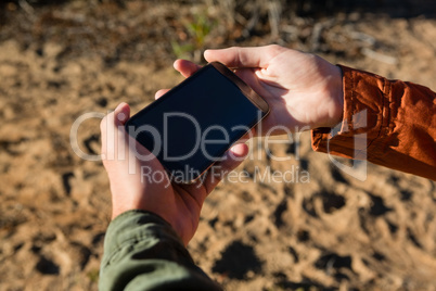 Cropped hands of couple using phone