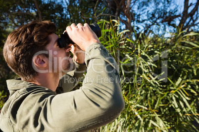 Young man looking through binocular