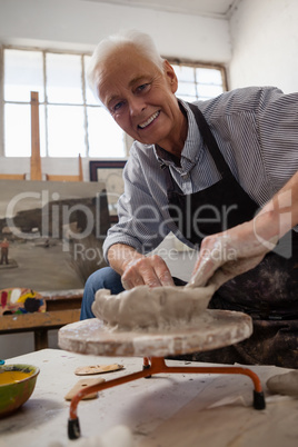 Portrait of senior man molding clay