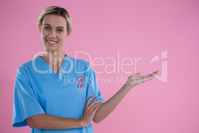 Portrait of smiling female doctor in scrubs gesturing