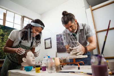 Woman and man learning pottery in class