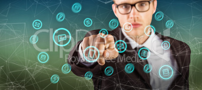 Composite image of young serious businessman pointing at camera