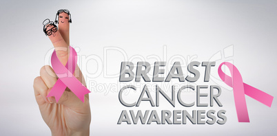 Composite image of cropped hand holding breast cancer awareness ribbon