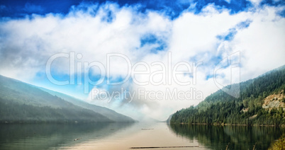 River amidst mountains against cloudy sky