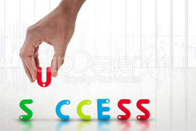 Composite image of cropped image of businessman arranging success word