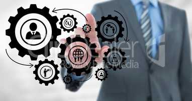 Business man interacting with people in cogs graphics against white background