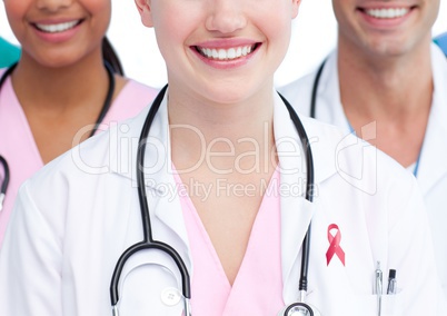 Happy doctors with breast cancer awareness ribbon