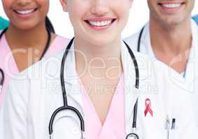 Happy doctors with breast cancer awareness ribbon