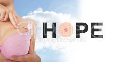 Hope text on Breast cancer woman with sky clouds background checking in bra