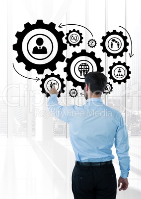 Business man interacting with people in cogs graphics against office background