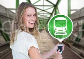 Woman holding phone with train icon on railway track