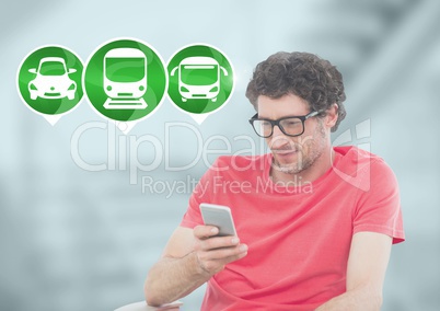 Man holding phone with transport icons in station