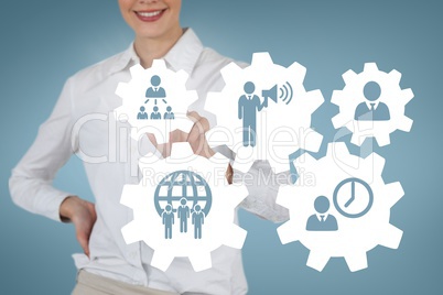 Business woman interacting with people in cogs graphics against blue background