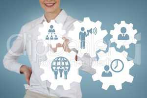 Business woman interacting with people in cogs graphics against blue background