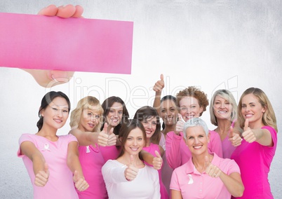 Hand holding card with pink breast cancer awareness women