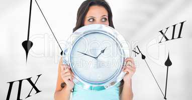 Woman holding a clock against background with clocks