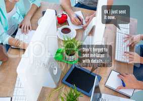 People working in office at desk with chat bubble at meeting