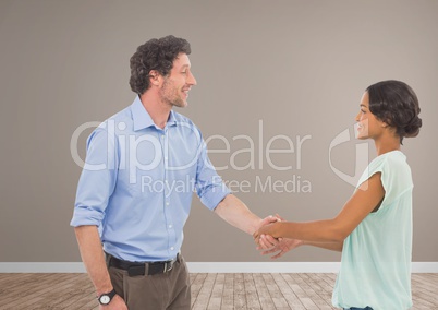 Man and woman shaking hands in brown room