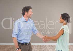Man and woman shaking hands in brown room