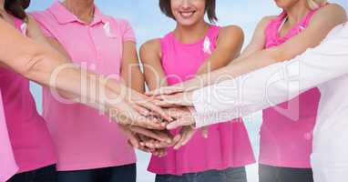 Breast cancer women holding hands with sky clouds background