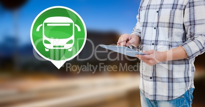 Holding tablet with bus icon by road