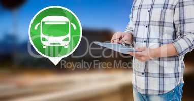 Holding tablet with bus icon by road