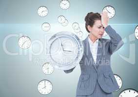 Business woman holding a clock against background with clocks