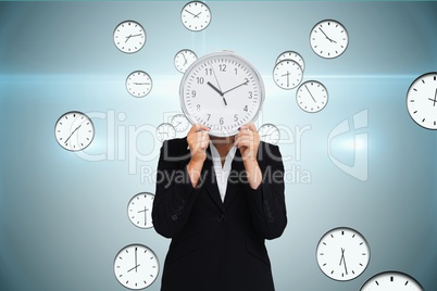 Business woman holding a clock against background with clocks