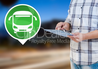 Holding tablet with bus icon by road