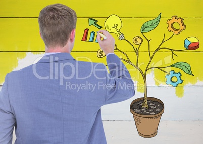 Man holding pen and Drawing of Business graphics on plant branches on wall