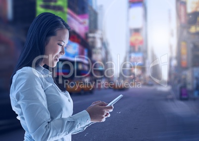 Woman holding phone in city