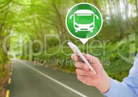 Hand holding phone with bus icon on road