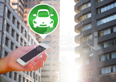 Hand holding phone with car icon in city
