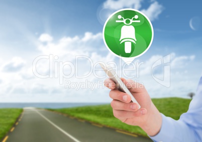 Hand holding phone with motorbike icon on road
