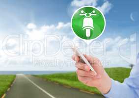 Hand holding phone with motorbike icon on road