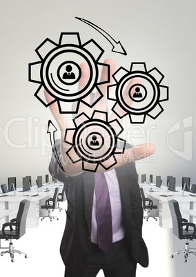 Business man interacting with people in cogs graphics against office background