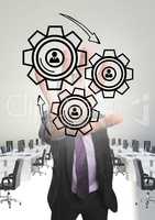 Business man interacting with people in cogs graphics against office background