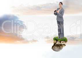 Businesswoman with binoculars on floating rock platform in sky