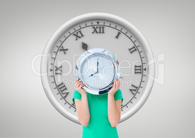 Woman holding a clock against background with clock